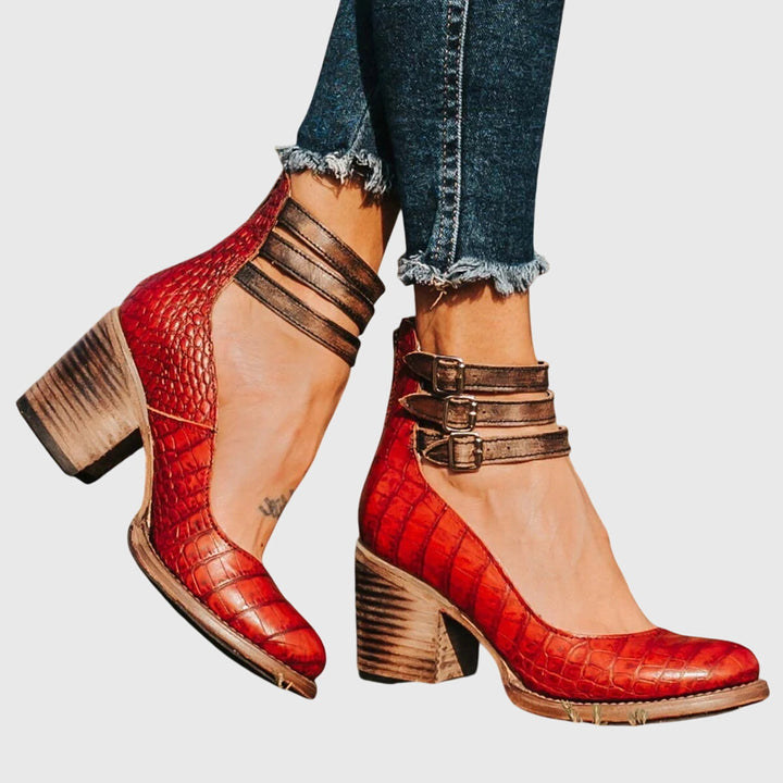 Trendy women's fashion ankle boots featuring stylish cutouts, a prominent buckle, and a confident block heel.