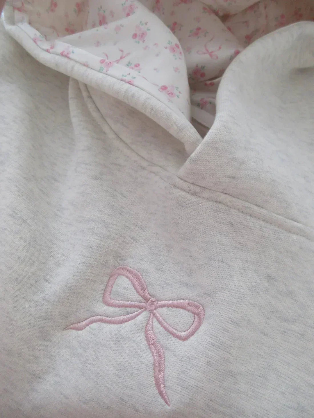 Versatile women's hoodie featuring an elegant bow, drawstring hood, and kangaroo pocket for chic casual wear.
