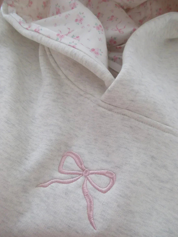 Versatile women's hoodie featuring an elegant bow, drawstring hood, and kangaroo pocket for chic casual wear.