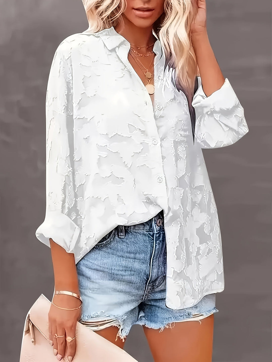 Close-up of the textured jacquard fabric on a sophisticated women's V-neck blouse. Perfect for elegant workwear.