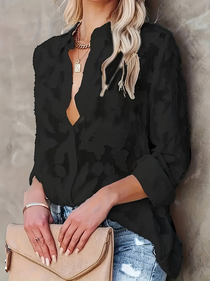 Woman wearing a stylish V-neck jacquard blouse with long sleeves, ideal for sophisticated workwear and professional outfits.