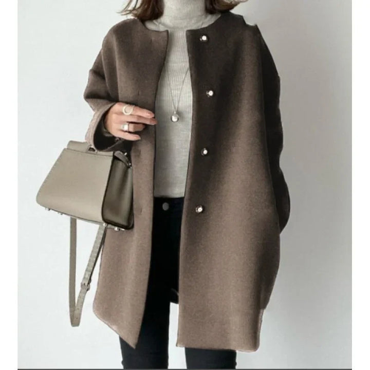 Women's long sleeve oversized button coat in a minimalist design. Versatile outerwear for fall/winter chic fashion.