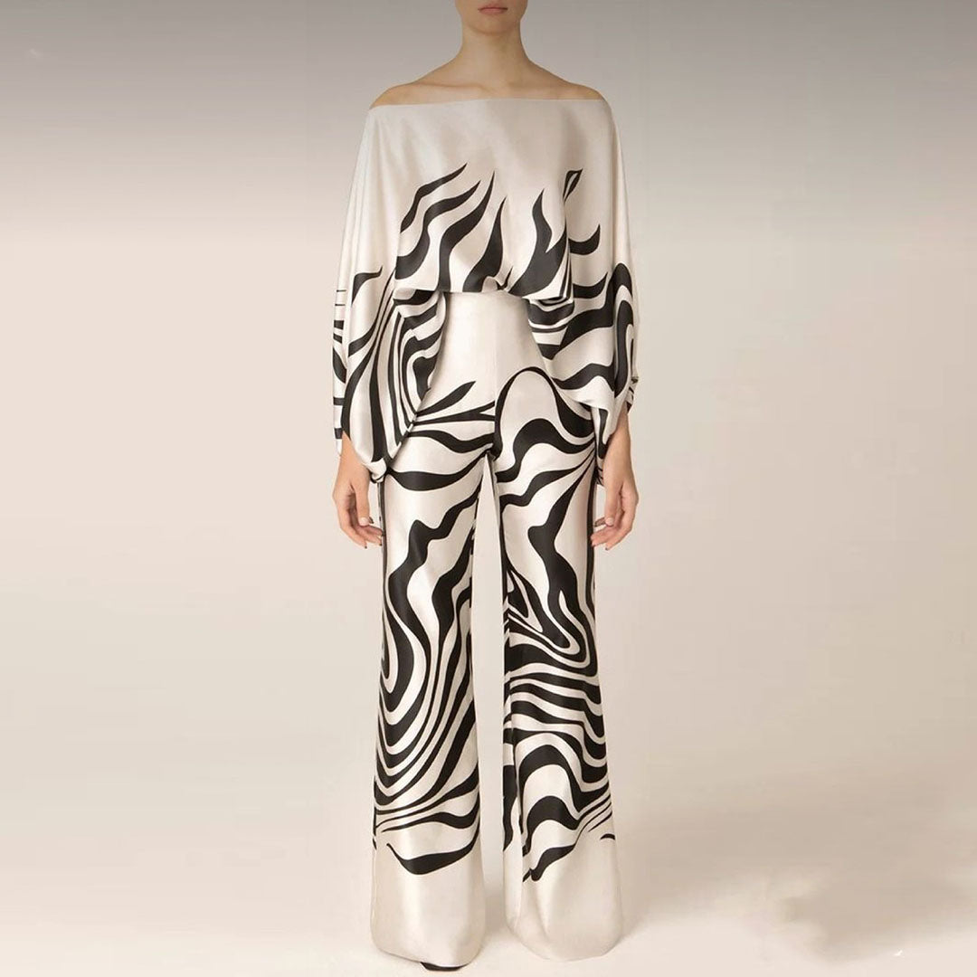 Vacation-ready women's one-shoulder two-piece set. Features a vibrant abstract print and comfortable wide-leg pants.