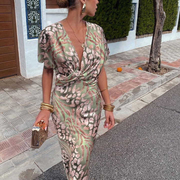 Flowing women's V-neck printed maxi dress with chic twist front detail, ideal for wedding guests.