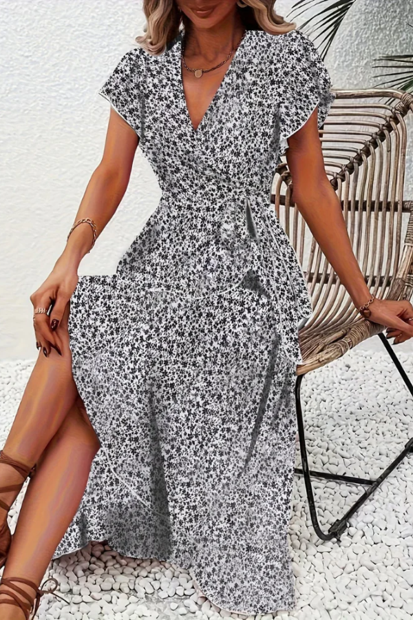 Close-up: V-neckline and vibrant floral print on a women's midi dress. Chic summer style.