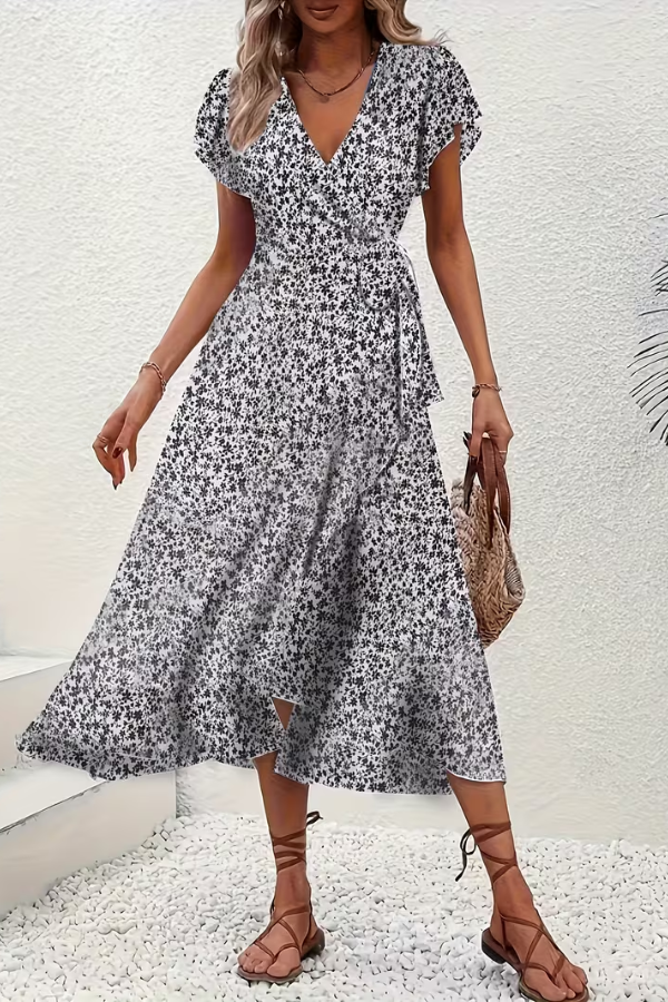 Textured detail of the lively floral pattern on an elegant women's V-neck midi dress. Lightweight.