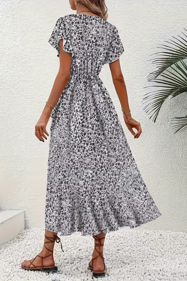 Woman gracefully walking in a chic V-neck floral midi dress. Perfect for summer events.