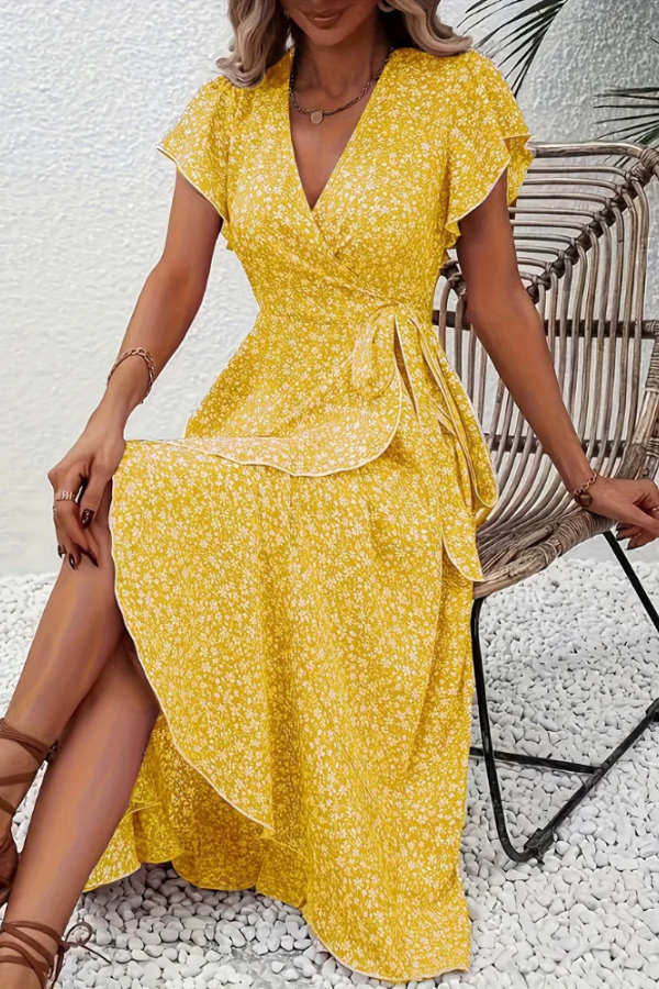 Woman sitting comfortably in a vibrant V-neck floral midi dress. Casual chic summer look.