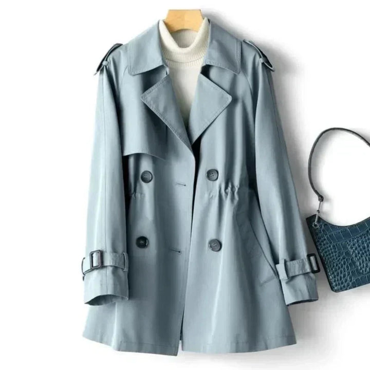 Chic women's trench coat; double-breasted, belted, & adjustable cuffs. Essential fall/spring fashion outerwear.