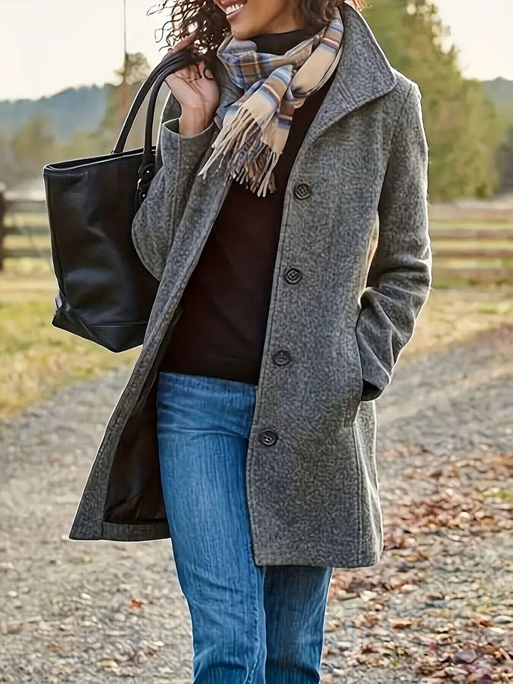 Stylish women's mid-length trench coat for fall fashion, featuring a classic lapel and button closure.