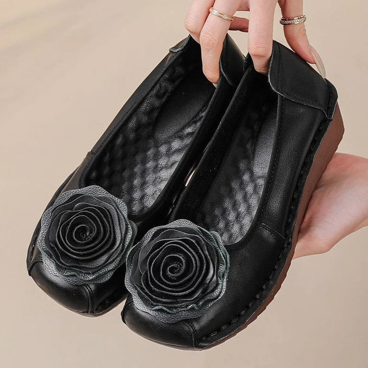 Stylish women's slip-on loafers featuring a delicate floral appliqué. Perfect casual comfort footwear.