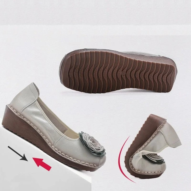 Front view of women's comfort footwear: slip-on loafers with intricate floral appliqué design.