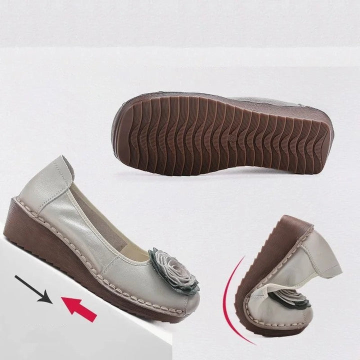 Front view of women's comfort footwear: slip-on loafers with intricate floral appliqué design.