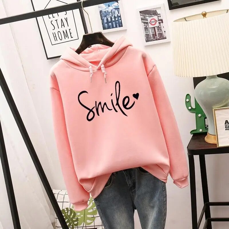 Trendy women's hooded sweatshirt with a positive smile graphic, perfect for relaxed fit casual wear.