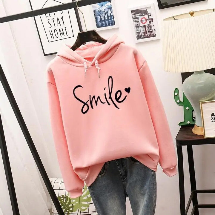 Trendy women's hooded sweatshirt with a positive smile graphic, perfect for relaxed fit casual wear.