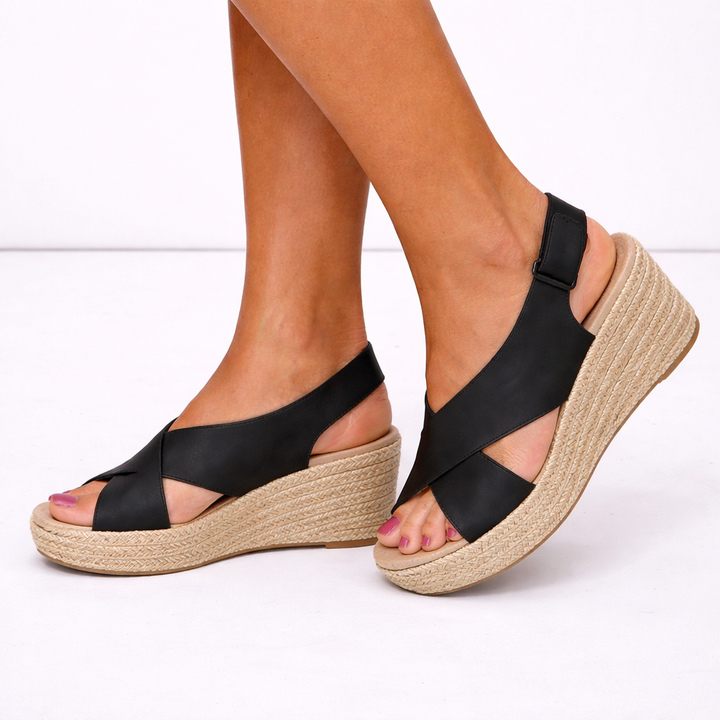 Chic women's wedge sandals featuring unique crossover straps, essential comfortable footwear for summer.