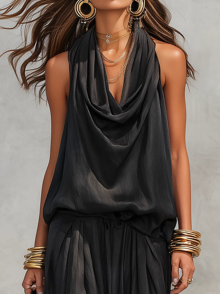 Women's draped cowl neck halter top paired with flowy wide leg pants, a chic two-piece resort outfit.