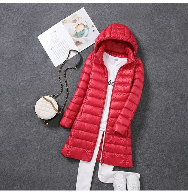 Stylish women's long puffer coat with hood, ideal fashion outerwear for winter & cold weather conditions.