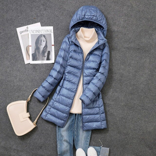Soft, insulated women's long puffer coat with hood, designed for ultimate warmth & winter weather protection.