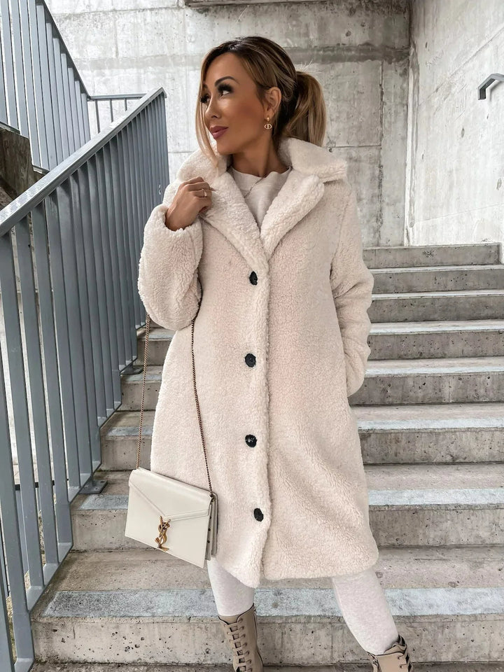 Soft plush teddy bear coat for women. Cozy longline jacket, ideal for warm, stylish winter fashion.