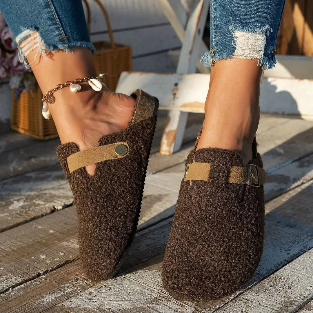 Pair of women's cozy slip-on mules, showcasing soft lining & anti-slip sole for winter comfort.