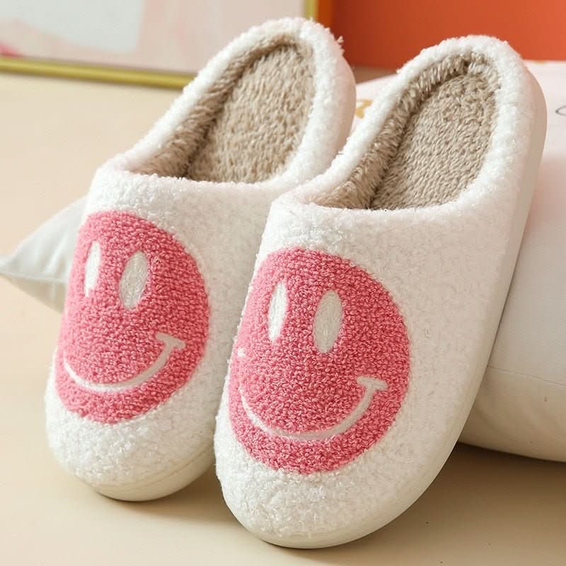 Pair of women's cozy winter smiley slippers, warm house shoes with a thick sole for plush indoor comfort.