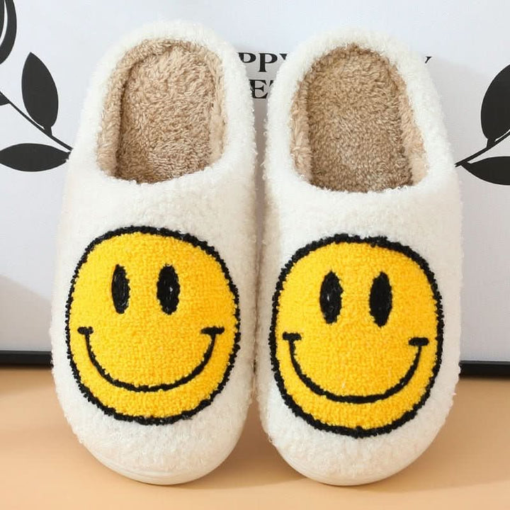 Woman wearing cozy smiley winter slippers, warm indoor house shoes with a thick sole for ultimate comfort.