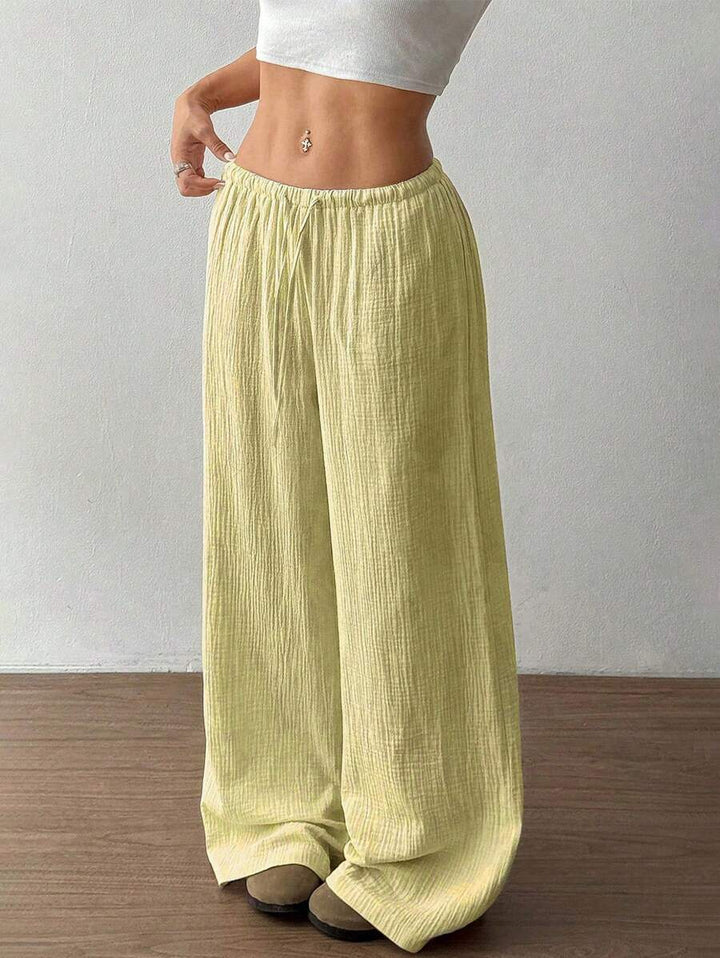 Detail of crinkle texture on women's wide-leg drawstring pants, emphasizing comfort and summer fashion.