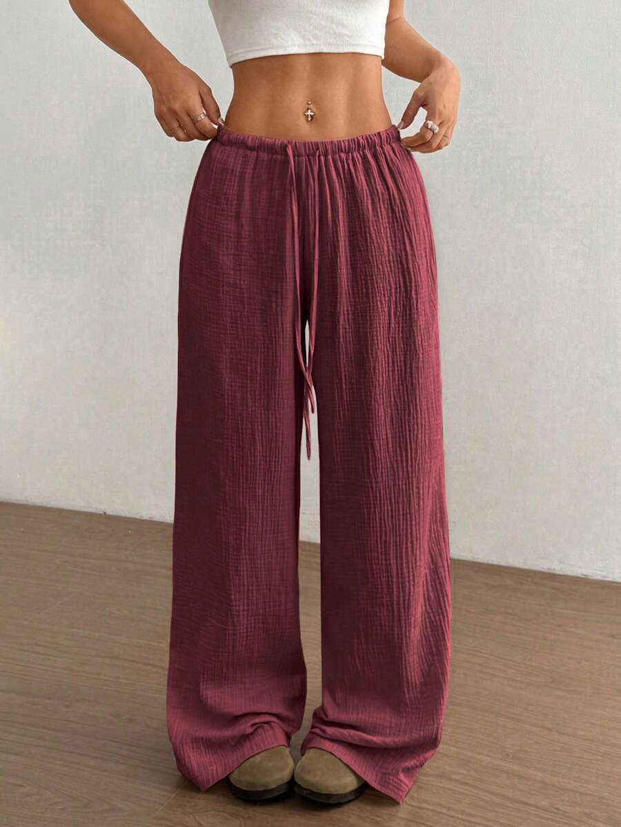 Relaxed fit women's crinkle wide-leg pants with drawstring, ideal for bohemian summer style.