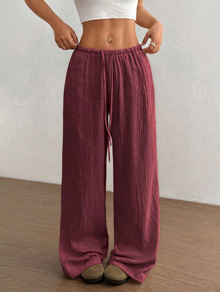 Relaxed fit women's crinkle wide-leg pants with drawstring, ideal for bohemian summer style.