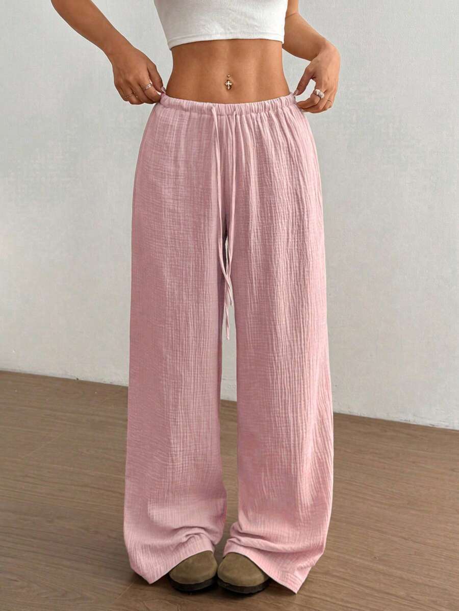 Model wearing relaxed fit women's crinkle wide-leg drawstring pants, showcasing comfortable summer style.