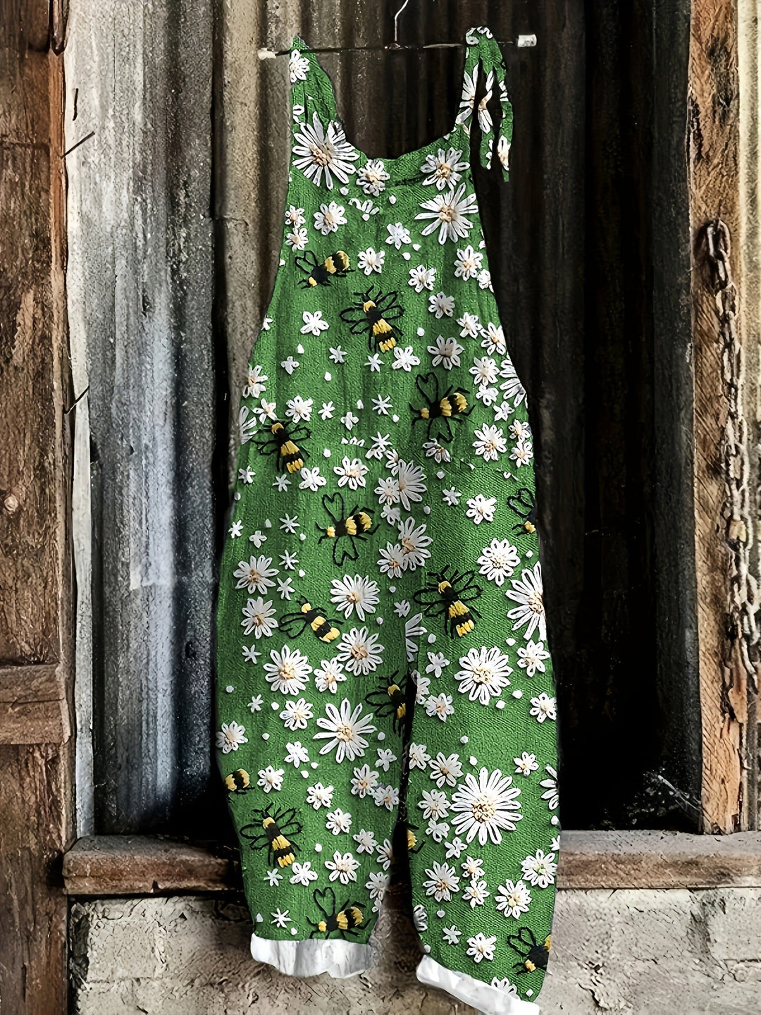 Back view: Relaxed fit women's daisy bee print jumpsuit with tie shoulder detail.