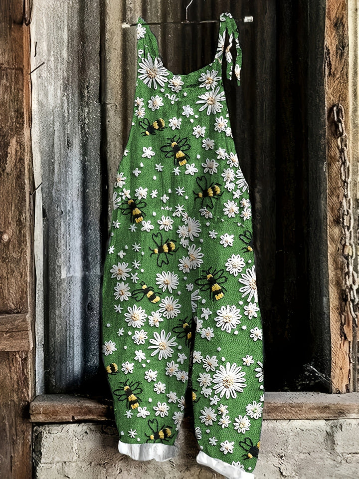 Back view: Relaxed fit women's daisy bee print jumpsuit with tie shoulder detail.