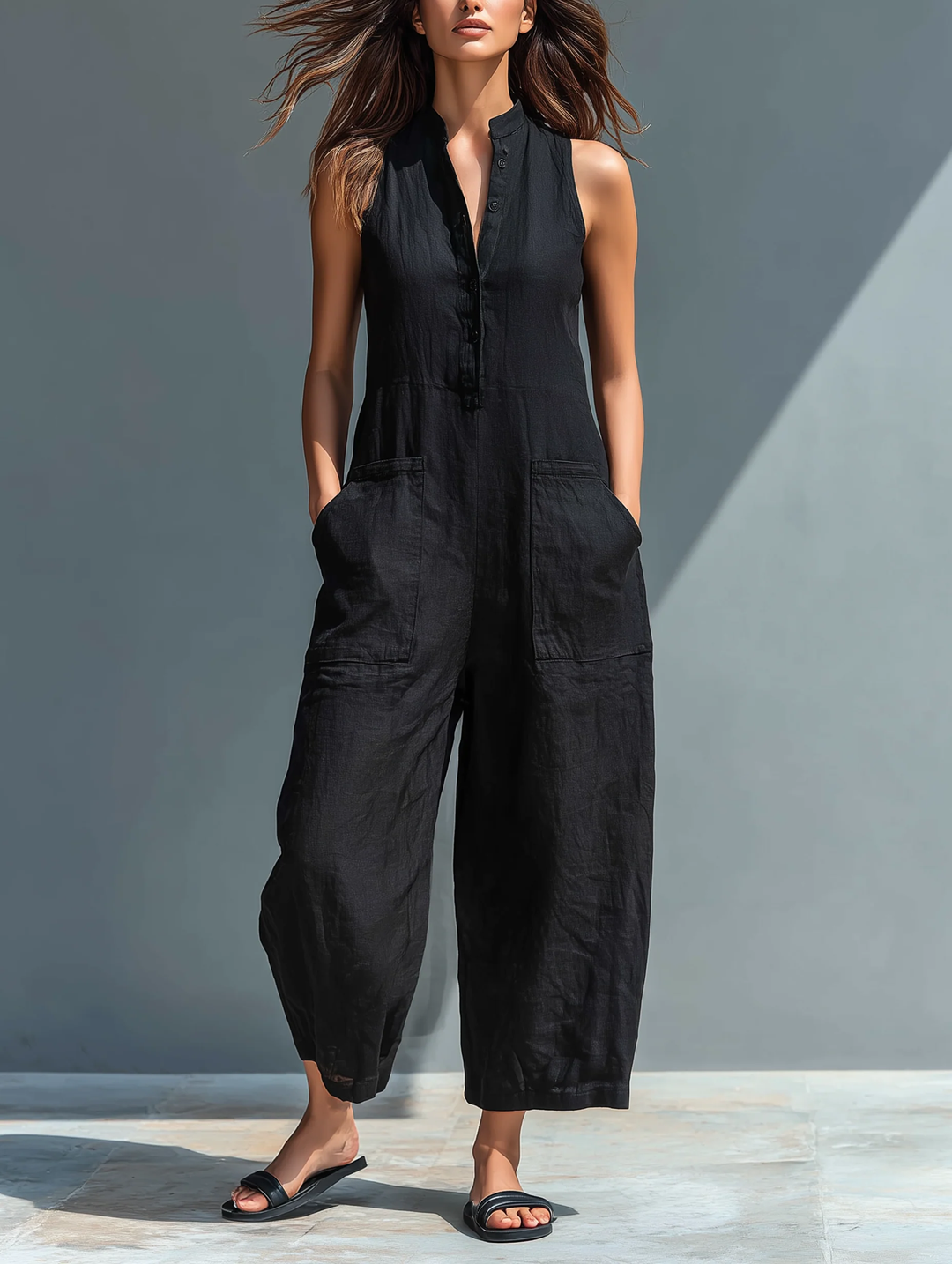 Women's effortless black loose fit jumpsuit with sleeveless design, stand collar, and button-up front. Casual wear.