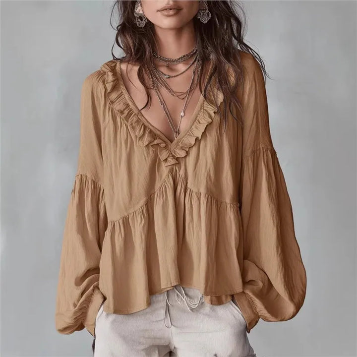 Women's effortless ruffle blouse with V-neck and puff sleeves. Stylish, loose-fit top for spring/summer comfort.