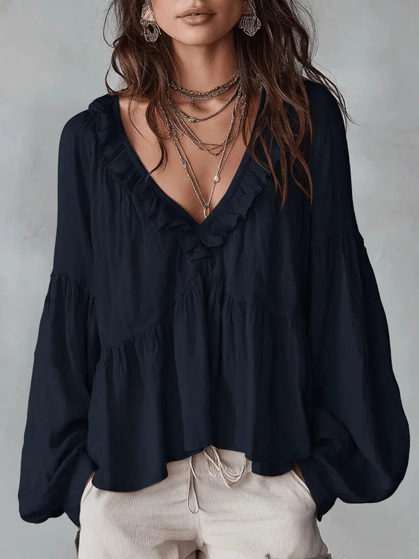 Comfortable women's ruffle blouse featuring a loose fit and puff sleeves. Lightweight V-neck top for casual summer style.