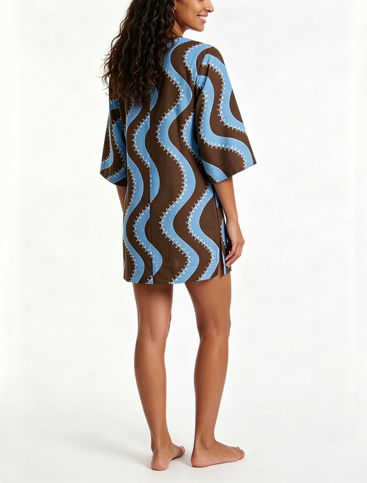 Stylish collared women's mini dress featuring a unique wave print, button front, and comfortable elbow sleeves.