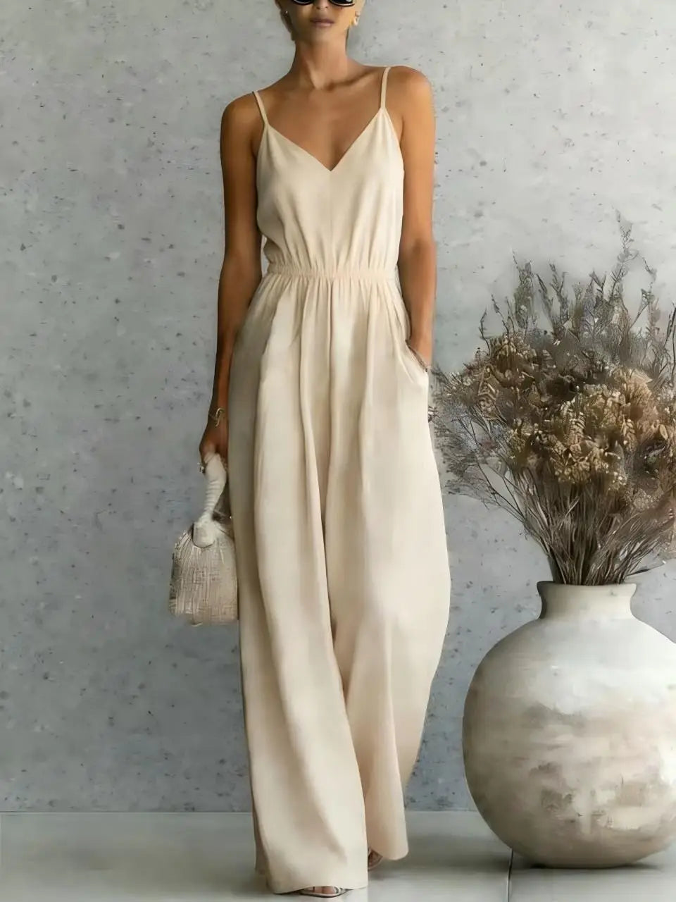Stylish V-neck wide-leg jumpsuit for women. Sleeveless, one-piece, ideal for relaxed summer days & vacations.
