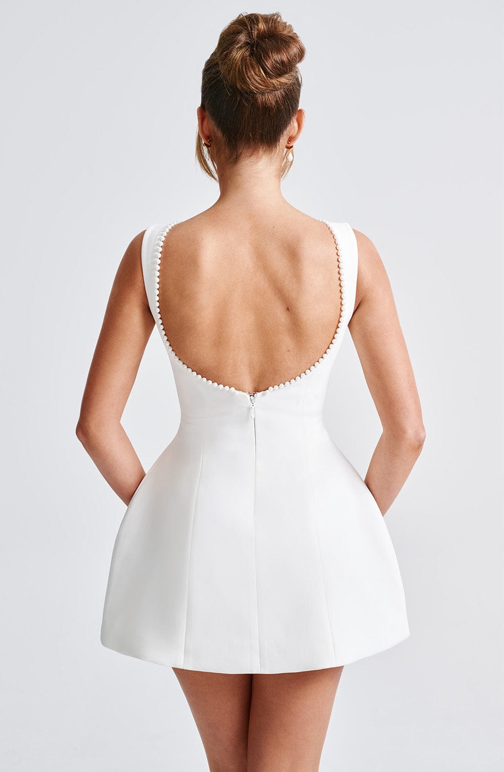 Women's elegant A-line mini homecoming dress, featuring delicate pearl trim and a chic bow, suitable for parties.