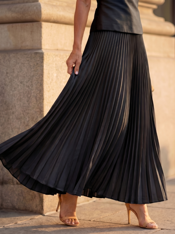 Chic black women's two-piece outfit with a structured top and a beautiful pleated maxi skirt.