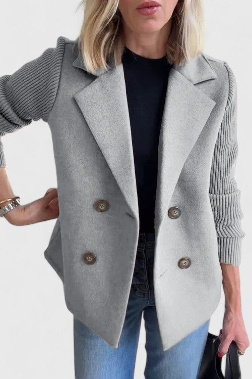 Woman wearing a sophisticated double-breasted blazer with comfort sleeves, styled for office.