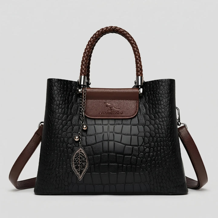 Black embossed tote bag for women. This stylish handbag features a unique braided handle & spacious design.