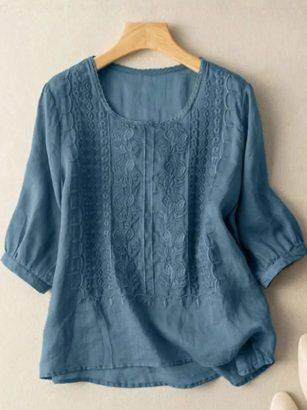 Close-up of elegant embroidery detail on a women's relaxed fit blouse, showcasing feminine style and comfort.