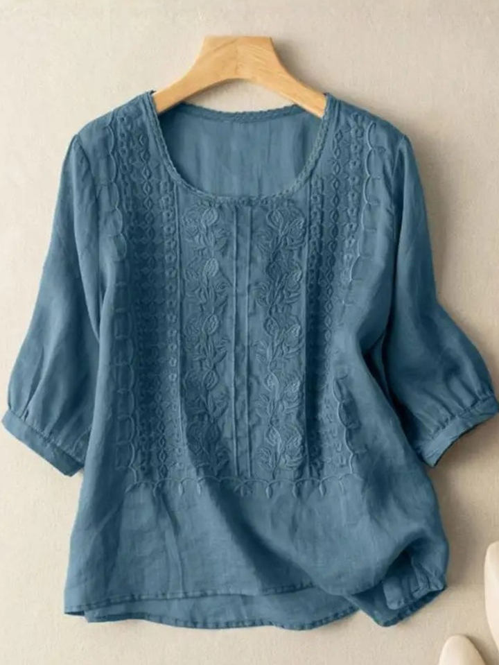 Close-up of elegant embroidery detail on a women's relaxed fit blouse, showcasing feminine style and comfort.