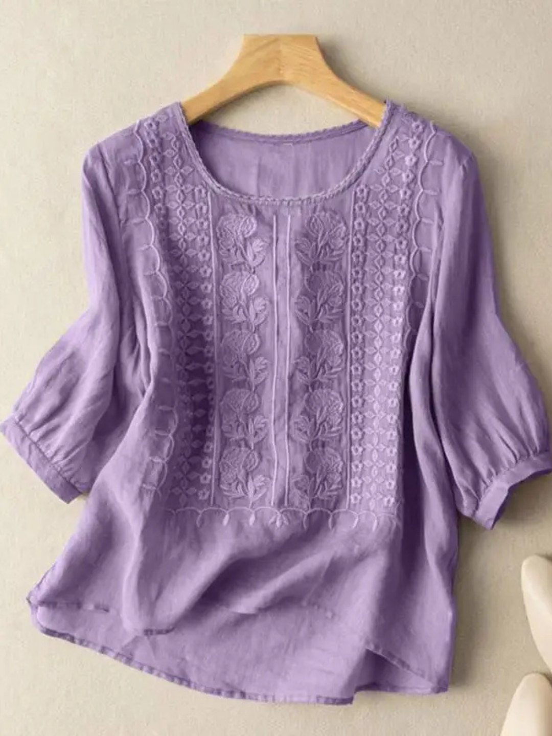 Woman wearing an elegant embroidered relaxed fit blouse, showcasing comfortable style & a fashionable feminine top.