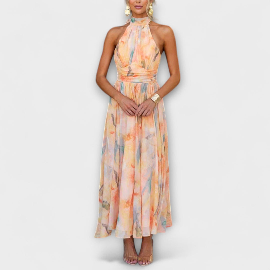 Women's elegant halter neck maxi dress with a flowing watercolor print, perfect for summer parties.