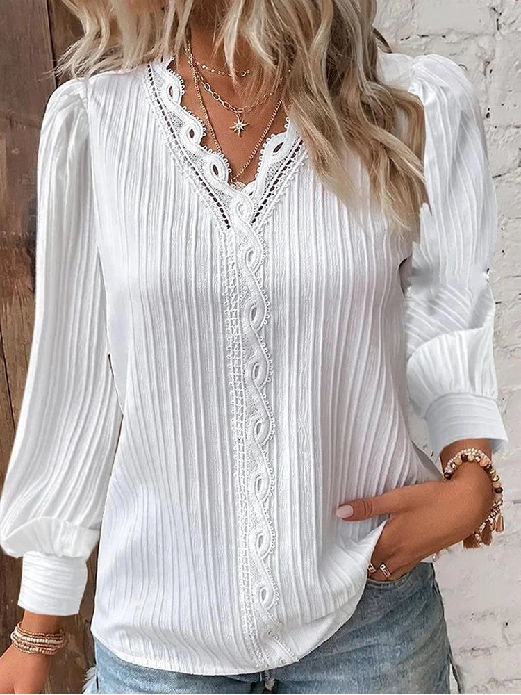 Front view of an elegant women's white blouse with delicate lace accents and fashionable puff sleeves.