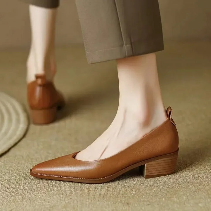 Close-up: Elegant women's pointed toe slip-on court shoes. Comfortable mid block heel detail.