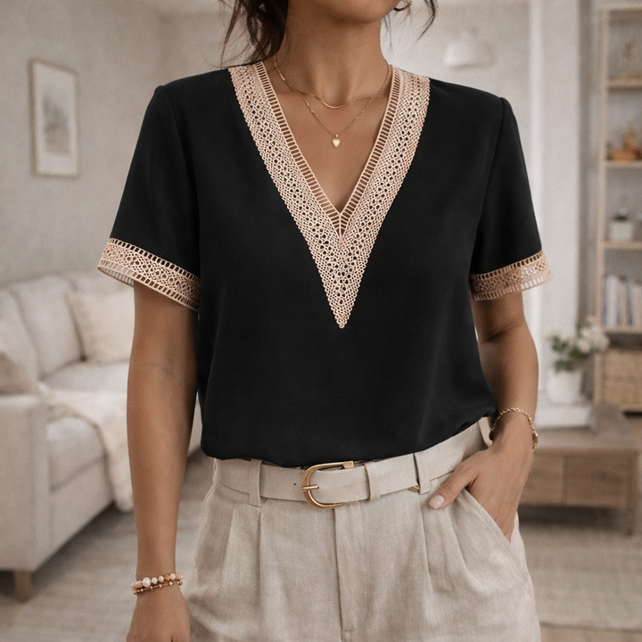 Close-up of elegant V-neck blouse for women, highlighting delicate lace trim and short sleeves.