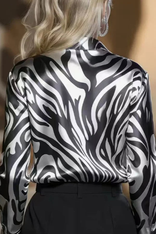 Chic women's zebra print button-down shirt, long sleeve. Elegant animal print top for sophisticated office & casual wear.